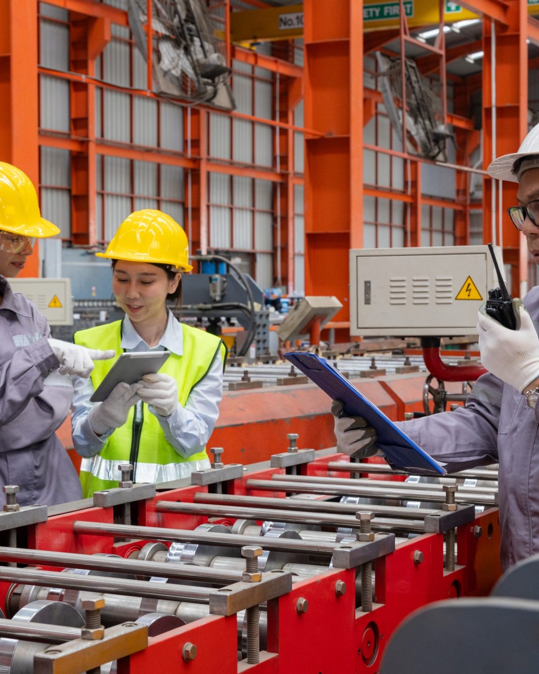 Engineers discussing machinery in manufacturing plant