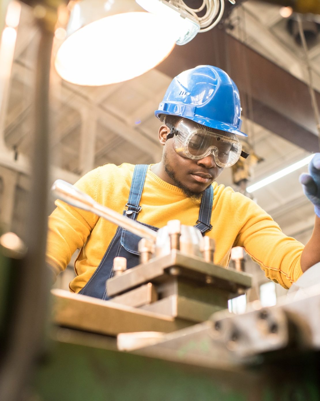 Serious worker repairing manufacturing machine